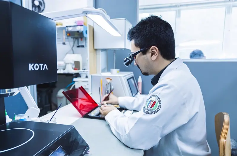 Técnico do IEM Lab trabalhando com lupa de precisão